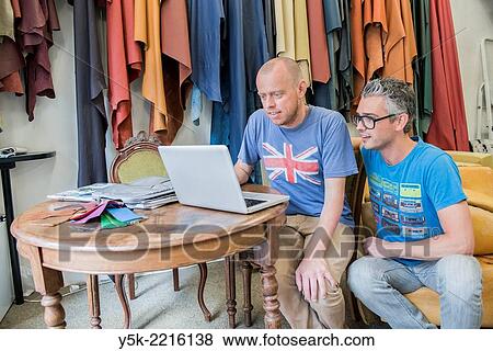 Tilburg, Netherlands. Josef and Werner are apprentice upholsterer and his male partner, both looking at an Apple´s notebook, viewing their newly made images. View Large Photo Image Stock Photo - Tilburg, Netherlands. Josef and Werner are apprentice upholsterer and his male partner, both looking at an Apple´s notebook, viewing their newly made images.. Fotosearch