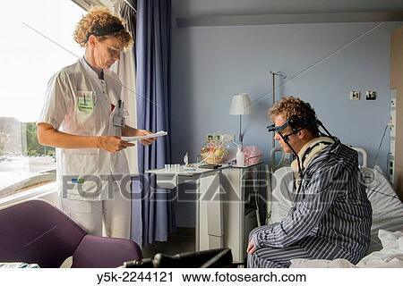 Tilburg, Netherlands. Physio therapist instructing a post operative patient with fractured cervical on how to walk again, after a head brace is mounted. View Large Photo Image Stock Image - Tilburg, Netherlands. Physio therapist instructing a post operative patient with fractured cervical on how to walk again, after a head brace is mounted.. Fotosearch