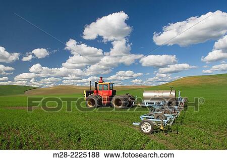 Tractor with implements in green wheat fields of the Palouse region of the Inland Empire of Washington. View Large Photo Image Stock Photo - Tractor with implements in green wheat fields of the Palouse region of the Inland Empire of Washington.. Fotosearch