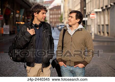Two young men in conversation in a street. View Large Photo Image Stock Photography - Two young men in conversation in a street.. Fotosearch
