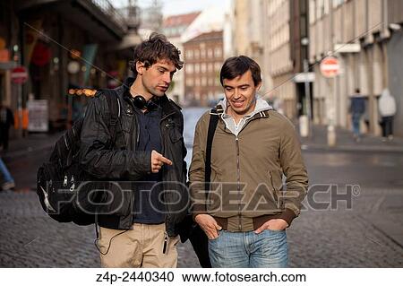 Two young people have a conversation on street. View Large Photo Image Stock Image - Two young people have a conversation on street.. Fotosearch