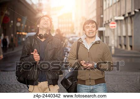 Two young people laughing in the street. View Large Photo Image Stock Image - Two young people laughing in the street.. Fotosearch