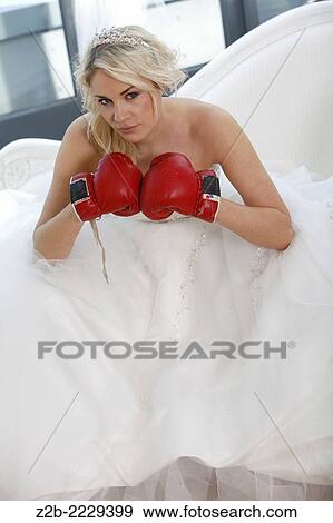 Stock Photo - Wedding dress worn by a model as she wears boxing gloves.. Fotosearch