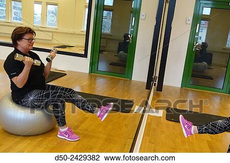 Stock Image - Weights in gym Exercise ball. Stockholm, Sweden. Fotosearch