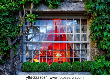 window with lights on inside, creeping plants around window from outside. View Large Photo Image Picture - window with lights on inside, creeping plants around window from outside.. Fotosearch