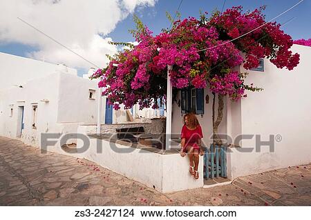 Picture - Woman in front of the Cyclades house in Artemonas village, Sifnos, Cyclades Islands, Greek Islands, Greece, Europe.. Fotosearch