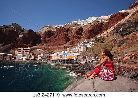 Woman standing on the rocks at the Ammoudi bay, Oia village, Santorini, Cyclades Islands, Greek Islands, Greece, Europe. View Large Photo Image Stock Photo - Woman standing on the rocks at the Ammoudi bay, Oia village, Santorini, Cyclades Islands, Greek Islands, Greece, Europe.. Fotosearch