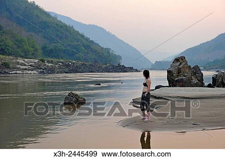 woman standing up on a sandbank on Mekong River, Pakbeng, Oudomxay Province, Laos, Southeast Asia. View Large Photo Image Stock Photo - woman standing up on a sandbank on Mekong River, Pakbeng, Oudomxay Province, Laos, Southeast Asia.. Fotosearch