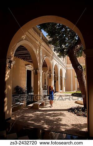 Stock Image - Woman walking inside the Merida city museum, Merida, Yucatan Province, Mexico, Central America.. Fotosearch