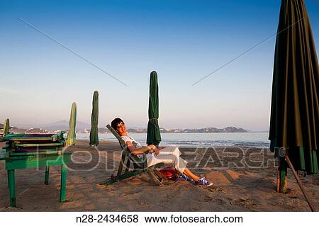 Woman watching the sunset sitting on a lounger chair Manzanillo beach Pacific Ocean Colima Mexico North America. View Large Photo Image Stock Photo - Woman watching the sunset sitting on a lounger chair Manzanillo beach Pacific Ocean Colima Mexico North America.. Fotosearch