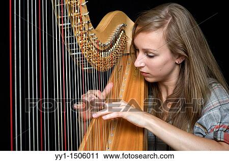 Young, female student at conservatoire playing harp at graduate level. View Large Photo Image Stock Image - Young, female student at conservatoire playing harp at graduate level.. Fotosearch