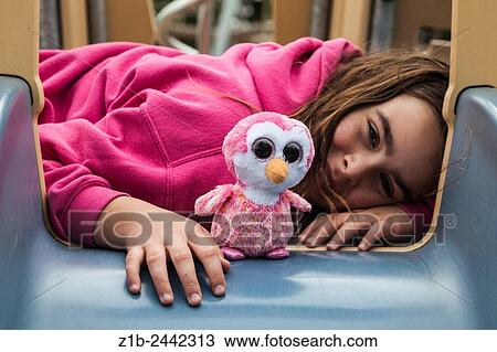 Young girl and her stuffed toy at the top of a slide at a playground park. View Large Photo Image Stock Image - Young girl and her stuffed toy at the top of a slide at a playground park.. Fotosearch