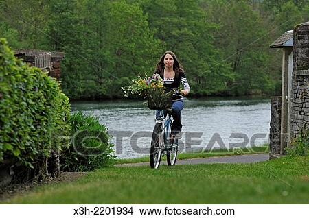 young woman cycling on cycle lane along the Meuse River at Haybes, Ardennes department, Champagne-Ardenne region of northeasthern France, Europe. View Large Photo Image Picture - young woman cycling on cycle lane along the Meuse River at Haybes, Ardennes department, Champagne-Ardenne region of northeasthern France, Europe.. Fotosearch