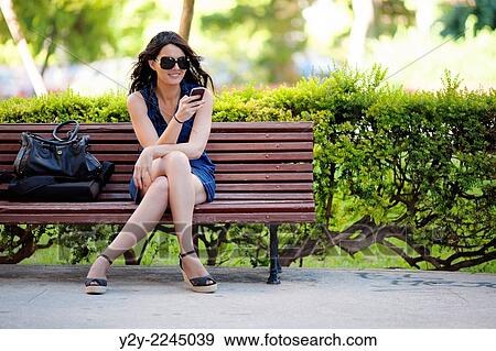 young woman sitting on bench. View Large Photo Image Stock Photo - young woman sitting on bench.. Fotosearch