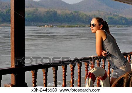 young woman standing at the railing of a cruise boat, owned by ´´ The Luang Say Lodge & Cruises´´, on Mekong River, between Pakbeng and Luang Prabang, Oudomxay Province, Laos, Southeast Asia. View Large Photo Image Stock Image - young woman standing at the railing of a cruise boat, owned by ´´ The Luang Say Lodge & Cruises´´, on Mekong River, between Pakbeng and Luang Prabang, Oudomxay Province, Laos, Southeast Asia.. Fotosearch