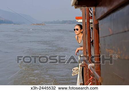 young woman standing at the railing of a cruise boat, owned by ´´ The Luang Say Lodge & Cruises´´, on Mekong River, between Pakbeng and Luang Prabang, Oudomxay Province, Laos, Southeast Asia. View Large Photo Image Stock Image - young woman standing at the railing of a cruise boat, owned by ´´ The Luang Say Lodge & Cruises´´, on Mekong River, between Pakbeng and Luang Prabang, Oudomxay Province, Laos, Southeast Asia.. Fotosearch