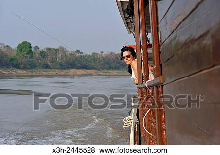 young woman standing at the railing of a cruise boat, owned by ´´ The Luang Say Lodge & Cruises´´, on Mekong River, between Pakbeng and Luang Prabang, Oudomxay Province, Laos, Southeast Asia. View Large Photo Image Stock Photo - young woman standing at the railing of a cruise boat, owned by ´´ The Luang Say Lodge & Cruises´´, on Mekong River, between Pakbeng and Luang Prabang, Oudomxay Province, Laos, Southeast Asia.. Fotosearch
