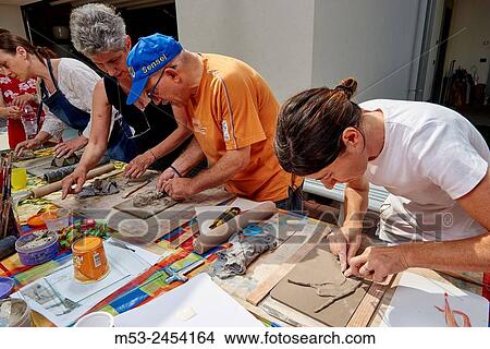 Amateur artists while modeling clay to obtain raku ceramics. View Large Photo Image Picture - Amateur artists while modeling clay to obtain raku ceramics.. Fotosearch