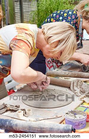 Amateur artists while modeling clay to obtain raku ceramics. View Large Photo Image Stock Image - Amateur artists while modeling clay to obtain raku ceramics.. Fotosearch