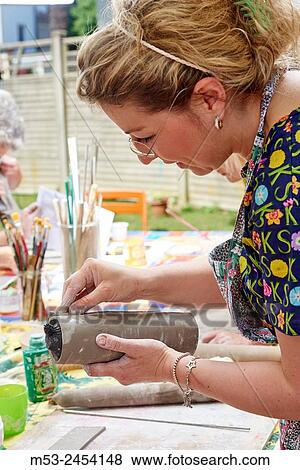 Amateur artists while modeling clay to obtain raku ceramics. View Large Photo Image Stock Photo - Amateur artists while modeling clay to obtain raku ceramics.. Fotosearch