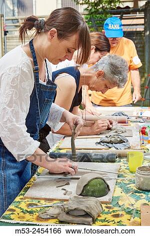 Amateur artists while modeling clay to obtain raku ceramics. View Large Photo Image Stock Photograph - Amateur artists while modeling clay to obtain raku ceramics.. Fotosearch