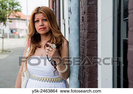 Amsterdam, Netherlands. Columbian female immigrant leaning against the drainpipe in front of her house. View Large Photo Image Picture - Amsterdam, Netherlands. Columbian female immigrant leaning against the drainpipe in front of her house.. Fotosearch
