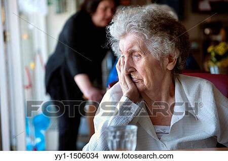 An elderly inhabitant of a Rotterdam nursing home with a glass of juice on the communal table. View Large Photo Image Picture - An elderly inhabitant of a Rotterdam nursing home with a glass of juice on the communal table.. Fotosearch