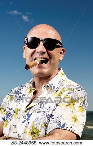 Stock Photo - Bald man in Hawaiian shirt, sunglasses and cigar on holiday.. Fotosearch