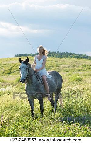 Barefoot girl in a white dress riding a grey horse. View Large Photo Image Stock Photo - Barefoot girl in a white dress riding a grey horse.. Fotosearch