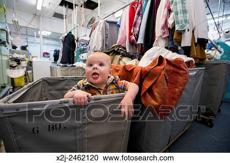 Broomfield, Colorado - Adam Hjermstad Jr., 10 months old, enjoys a makeshift playpen in a clothes bin at Lionheart Cleaners. MR. View Large Photo Image Stock Image - Broomfield, Colorado - Adam Hjermstad Jr., 10 months old, enjoys a makeshift playpen in a clothes bin at Lionheart Cleaners. MR.. Fotosearch