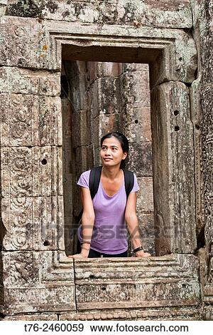 Stock Photo - Contemplating the Bayon temple at Angkor Wat in Siem Reap, Cambodia.. Fotosearch