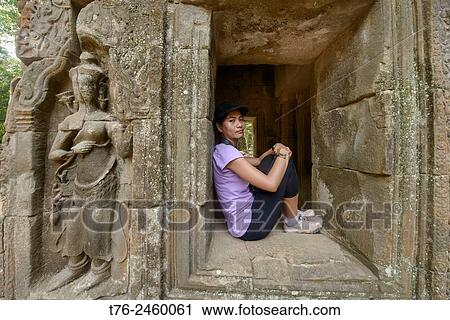Stock Image - Contemplating the Ta Phrom temple at Angkor Wat in Siem Reap, Cambodia.. Fotosearch