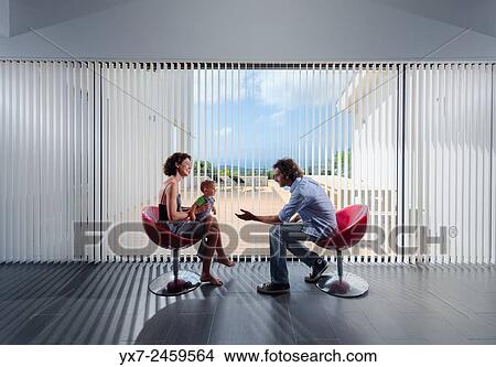 Picture - Couple with a baby in a modern house.. Fotosearch