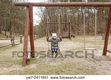 Stock Image - Girl on a swing in Mlociny Park, Warsaw, Poland.. Fotosearch