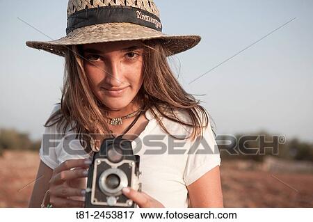Stock Photo - girl taking a picture with old camera, Peniscola, Spain. Fotosearch