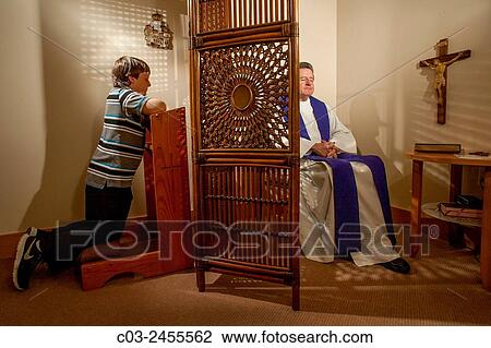 Hidden by a screen, a priest hears confession from a kneeling boy parishioner at a Laguna Niguel, CA, Catholic church. Note vestments. MODEL RELEASE. View Large Photo Image Stock Image - Hidden by a screen, a priest hears confession from a kneeling boy parishioner at a Laguna Niguel, CA, Catholic church. Note vestments. MODEL RELEASE.. Fotosearch