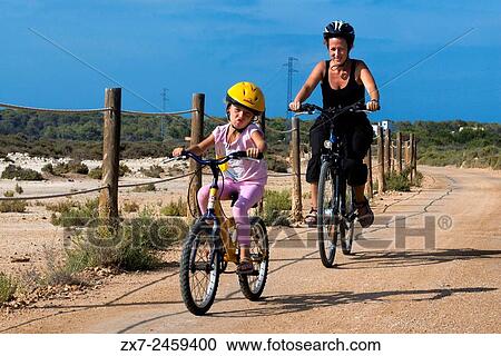 Mother and daughter are riding in a bike. Pudent Lake. Formentera. Balearic Islands, Spain, Europe. Bicycle route. View Large Photo Image Stock Image - Mother and daughter are riding in a bike. Pudent Lake. Formentera. Balearic Islands, Spain, Europe. Bicycle route.. Fotosearch