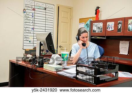 Stock Image - New York, USA. Female social worker with Goddard Riverside, receiving a 311 call, about a homeless person in Manhattan in need of help.. Fotosearch