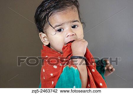 Stock Image - One Year old baby covered with towel and looking towards camera.. Fotosearch