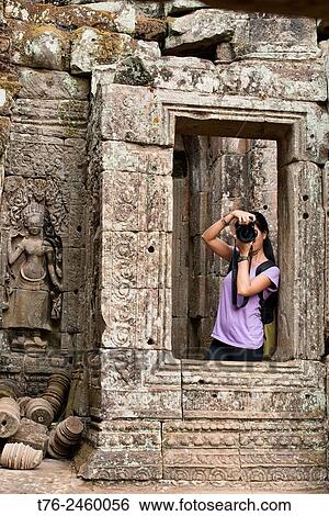 Stock Photograph - Photographer enjoying the Bayon temple at Angkor Wat in Siem Reap, Cambodia.. Fotosearch
