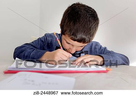 Primary schoolboy working on his homework. View Large Photo Image Stock Photo - Primary schoolboy working on his homework.. Fotosearch
