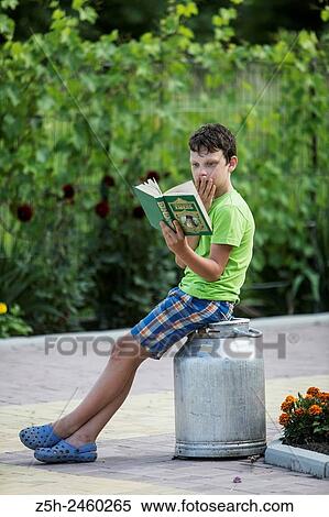 Russia. Belgorod region. Solomino village. The boy in the meadow with a book. View Large Photo Image Stock Photography - Russia. Belgorod region. Solomino village. The boy in the meadow with a book.. Fotosearch