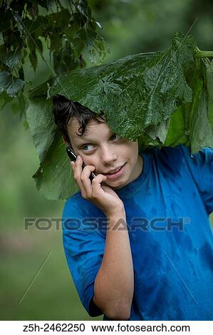 Russian Federation. Belgorod region. The boy in the rain uryvshiysya leaves of the plant. View Large Photo Image Stock Image - Russian Federation. Belgorod region. The boy in the rain uryvshiysya leaves of the plant.. Fotosearch