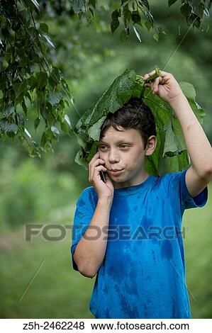 Russian Federation. Belgorod region. The boy in the rain uryvshiysya leaves of the plant. View Large Photo Image Stock Photo - Russian Federation. Belgorod region. The boy in the rain uryvshiysya leaves of the plant.. Fotosearch