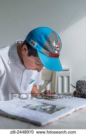 Stock Image - Schoolboy reading out his diary.. Fotosearch