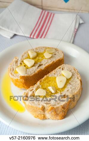 Stock Photograph - Sliced bread with olive oil and garlic.. Fotosearch
