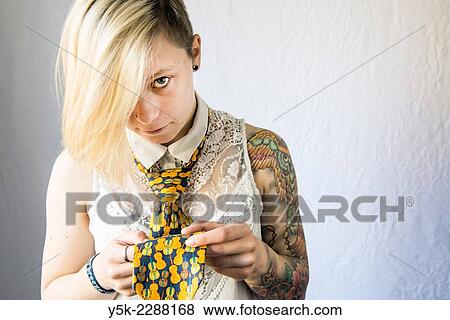 Studio Tuinstraat, Tilburg, Netherlands. Studio portrait of a young woman with large tatoo on her left arm and holding a tie. View Large Photo Image Stock Photo - Studio Tuinstraat, Tilburg, Netherlands. Studio portrait of a young woman with large tatoo on her left arm and holding a tie.. Fotosearch