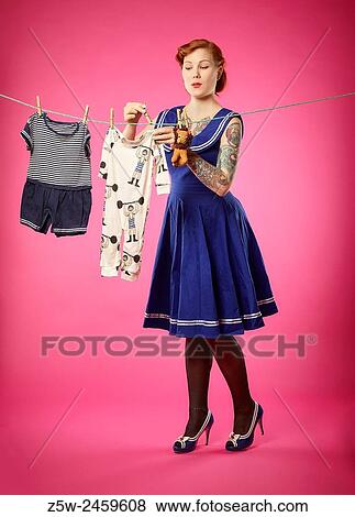 The expectant woman hang up baby clothes to clothesline. View Large Photo Image Stock Photo - The expectant woman hang up baby clothes to clothesline.. Fotosearch