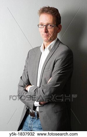 Stock Image - Tilburg, Netherlands. Studio-portrait of a long man with glasses.. Fotosearch