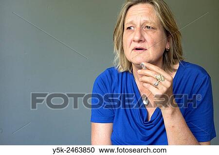 Tilburg, Netherlands. Studio portrait of a middle aged woman smoking a cigarette. View Large Photo Image Stock Image - Tilburg, Netherlands. Studio portrait of a middle aged woman smoking a cigarette.. Fotosearch